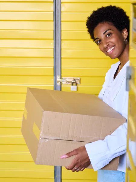 smiling-young-woman-standing-in-warehouse-with-car-2024-10-18-08-53-30-utc 2 | Choose and Move Cargo LLC climate-controlled storage