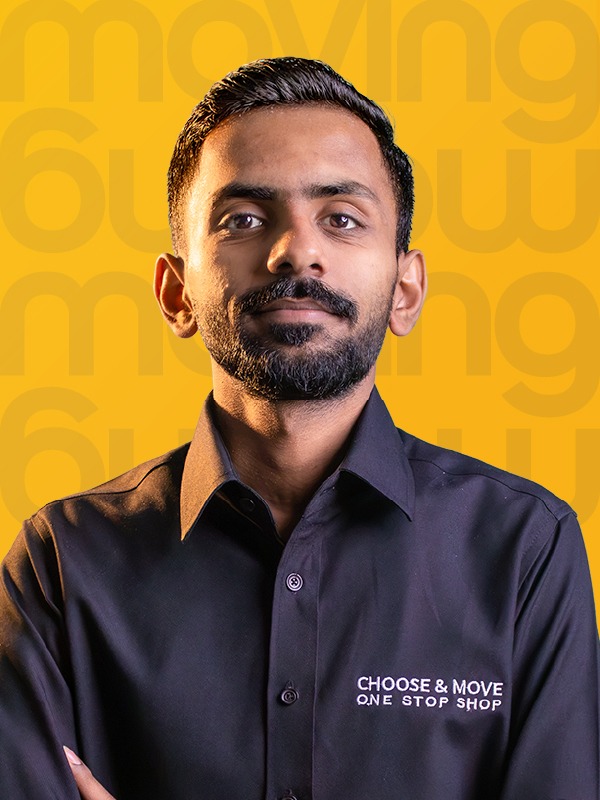 portrait of a man in a dark shirt with the 'choose & move' logo, posing against a bright yellow backdrop.