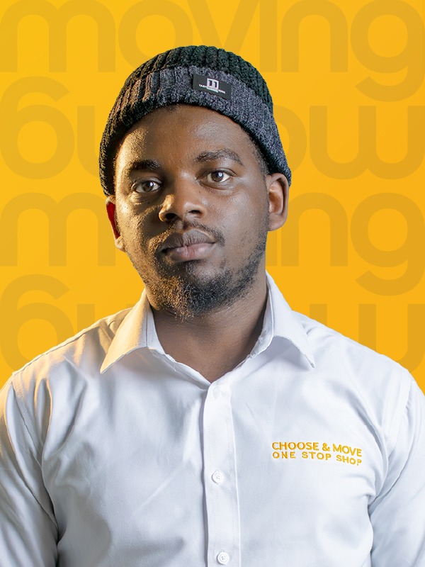 portrait of a man wearing a white shirt with the orange text 'choose & move one stop shop' on the chest, a black knit beanie, and a neutral expression, posed against a bright yellow backdrop with a repeating pattern.